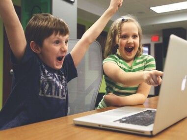 Zwei Kinder vor einem Laptop